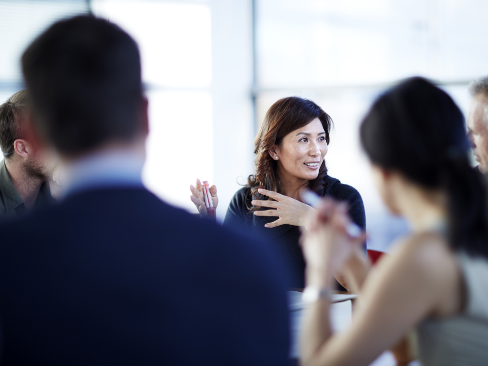 Group of people sitting around desk in a meeting