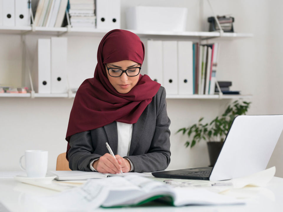 Woman in headscarf studying at desk