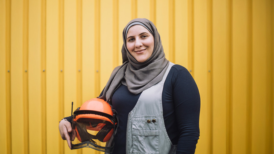 Woman in headscarf holding helmet