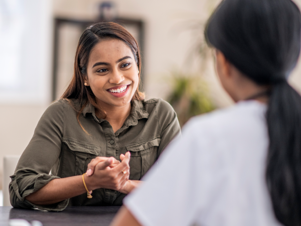 Woman smiling while having a conversation with another person