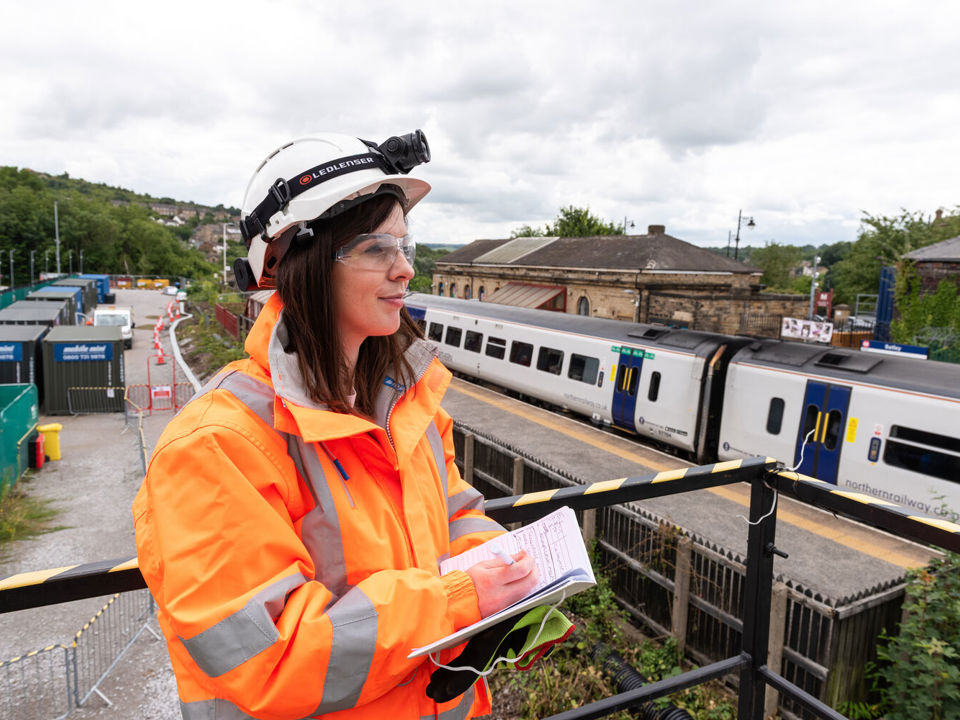 Female IOSH member in high-viz at station
