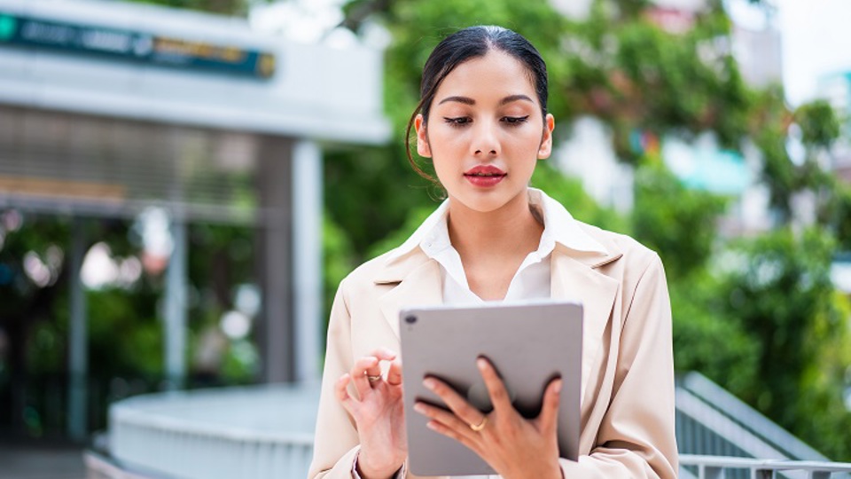 Woman using tablet computer outdoors