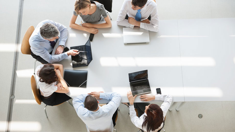 Aerial shot of people sitting at table in business meeting